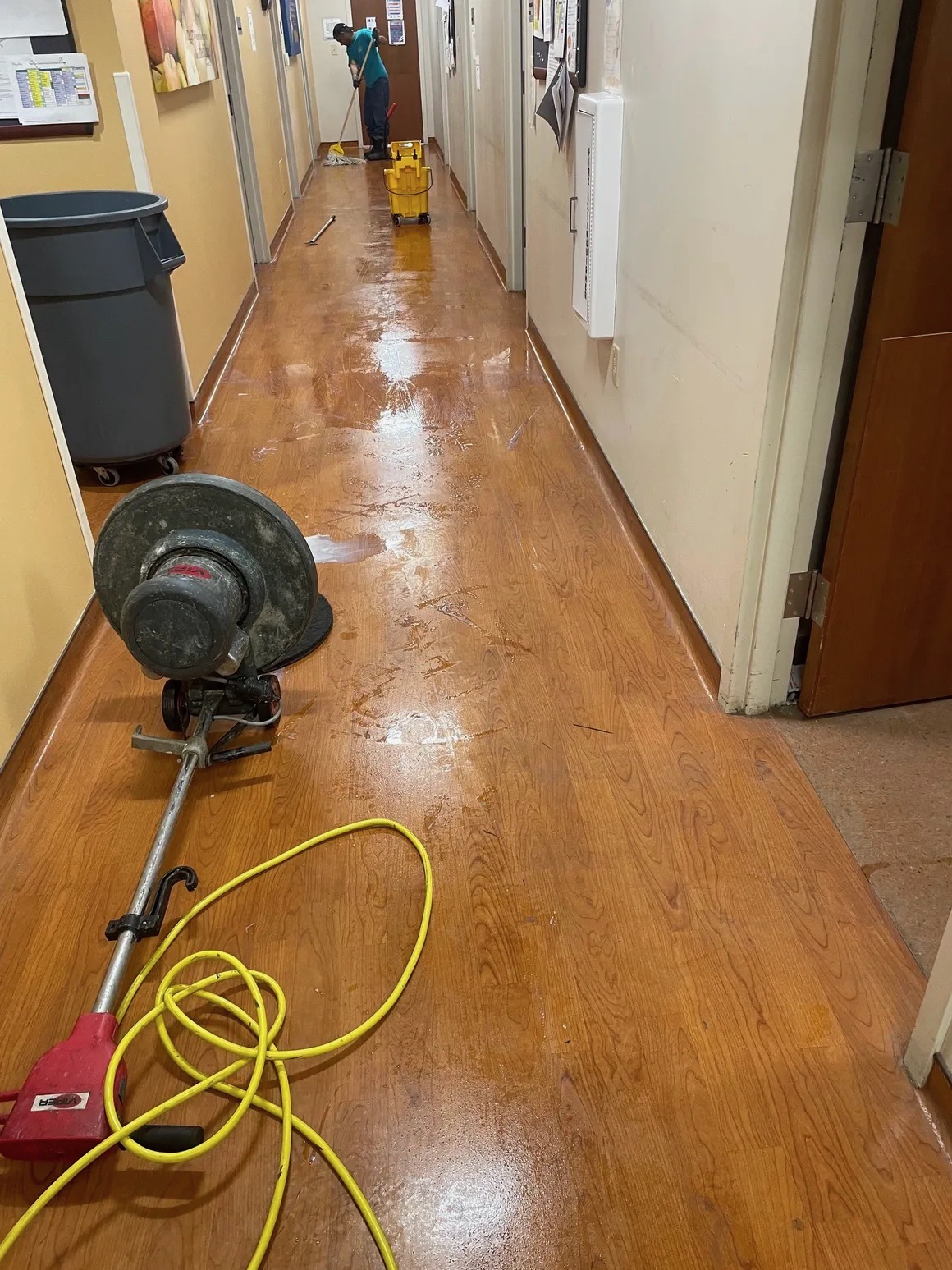 Floor machine refinishing a corridor at a medical facility