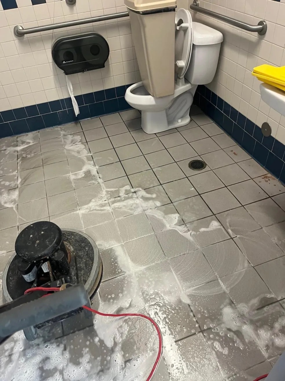 Machine scrubbing of a tiled restroom floor